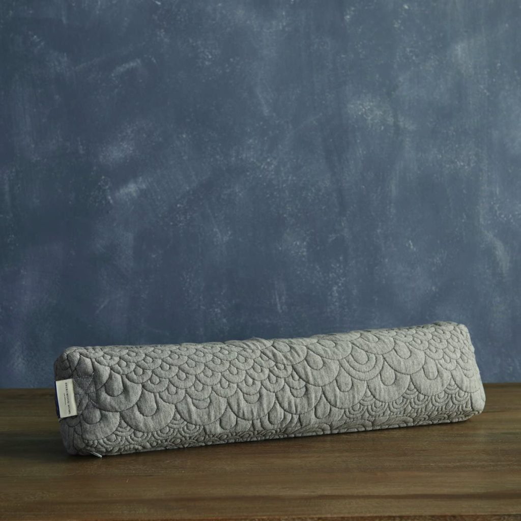 Image of a gray bolster on a table.  